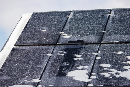 Solar panels covered with snow and ice in winter, renewable energy in frost
