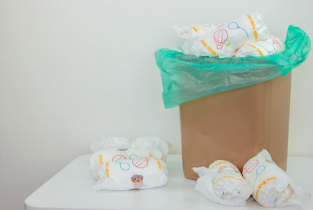 Used baby diapers in a trash bag, concept of childcare and environmental impact.の写真素材
