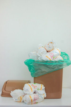 Used baby diapers in a trash bag, concept of childcare and environmental impact.の写真素材