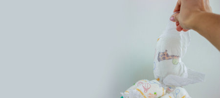 Hand used throwing diaper into trash bin, concept of hygiene and waste disposal.の写真素材