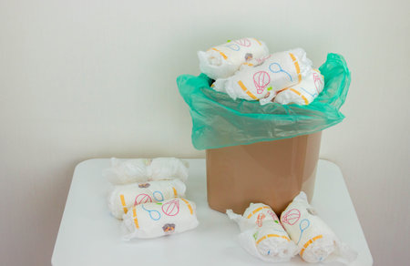 Used baby diapers in a trash bag, concept of childcare and environmental impact.の写真素材