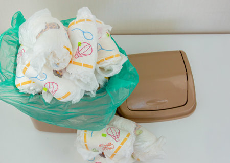 Used baby diapers in a trash bag, concept of childcare and environmental impact.の写真素材