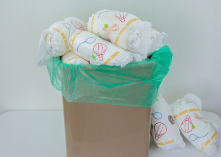 Used baby diapers in a trash bag, concept of childcare and environmental impact.の写真素材