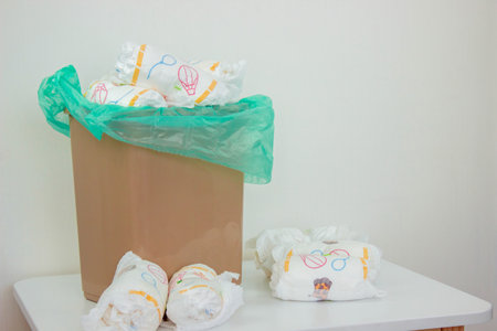 Used baby diapers in a trash bag, concept of childcare and environmental impact.の写真素材