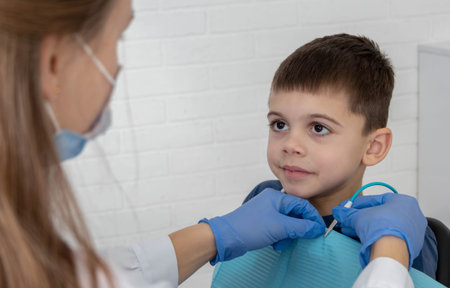 Dentist preparing little boy for examination, concept of pediatric dentistry and care.