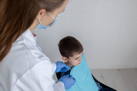 Dentist preparing little boy for examination, concept of pediatric dentistry and care.