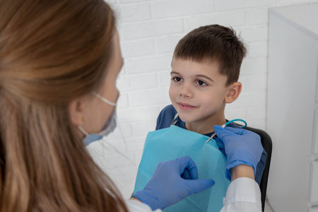 Dentist preparing little boy for examination, concept of pediatric dentistry and care.の写真素材
