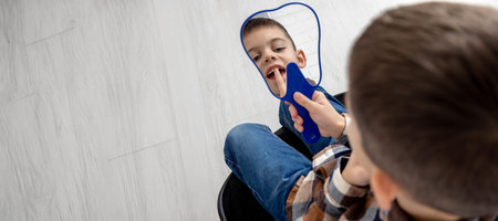 Little boy looking in the mirror at his loose primary tooth
