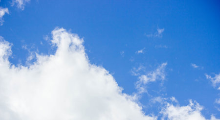 Blue sky with white fluffy clouds on a sunny day.