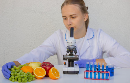Female scientist checking fresh fruit quality in science laboratory.