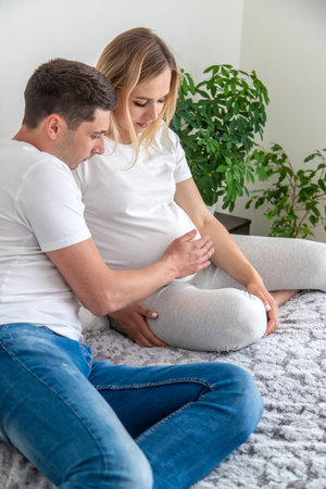 Pregnant woman with a man at home. Selective focus. Love.