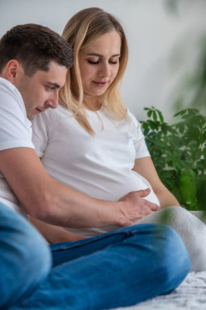 Pregnant woman with a man at home. Selective focus. Love.