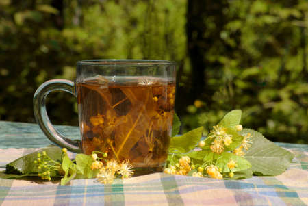 Cup with linden tea on a textile napkin の写真素材