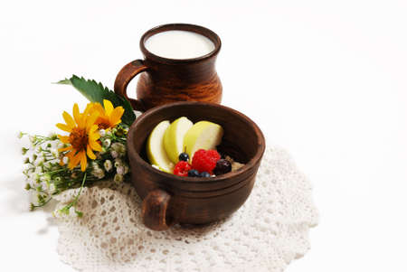 Milk and curd with summer fruits in brown ceramic bowls, isolated on a white backgroundの写真素材