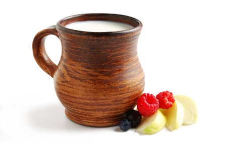 Milk in brown ceramic bowl and summer fruits isolated on a white backgroundの写真素材