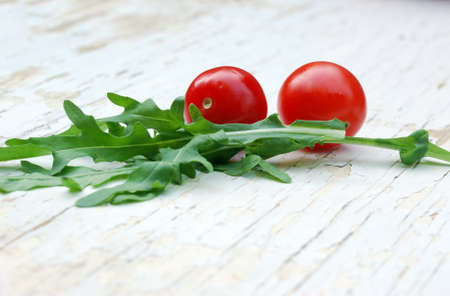 rocket salad and cherry tomatoes on a grunge tableの写真素材