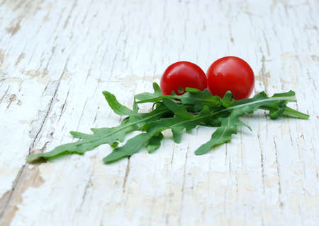 rocket salad and cherry tomatoes on a grunge tableの写真素材