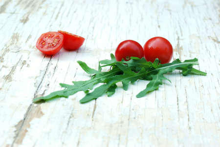 rocket salad and cherry tomatoes on a grunge tableの写真素材