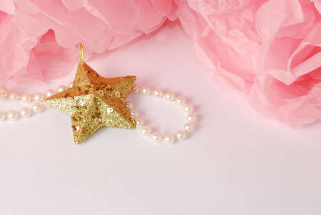 Decorative star, pearl beads and pink and white pom pom.Greeting or invitation card with copyspaceの写真素材