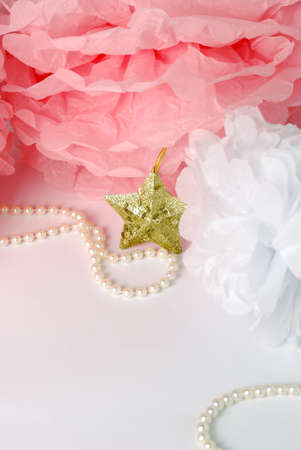 Decorative star, pearl beads and pink and white pom pom.Greeting or invitation card with copyspaceの写真素材