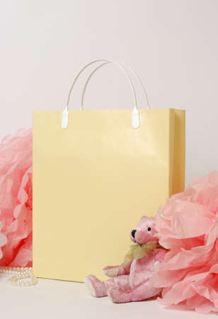 Beige gift bag with a paper decor, pom-pom and teddy bearの写真素材