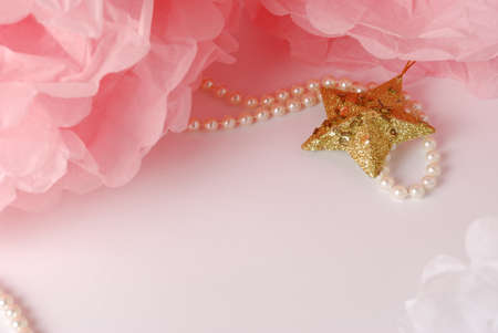 Decorative star, pearl beads and pink and white pom pom.Greeting or invitation card with copyspaceの写真素材