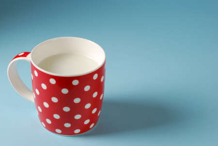 red cup of milk on a blue backgroundの写真素材
