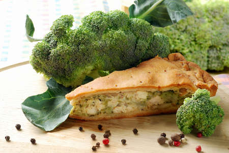 Pie with broccoli on a wooden table with fresh vegetebles and spicesの写真素材