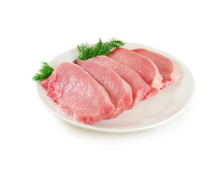 Raw meat. Pork steak with dill in a plateの写真素材