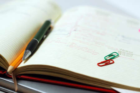 Pen and pencil on a open diary close-upの写真素材
