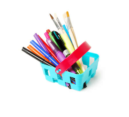 Color pencils, felt-tip pens, brushes and pens in a blue toy basket isolated on a white background. School shopping theme.の写真素材