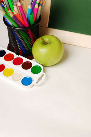 Group of school and office supplies with chalkboard watercolor paints, stack of colored pencils and markers,isolated on whiteの写真素材