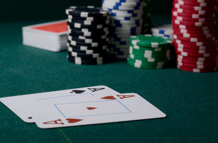 Stack of casino chips and two aces on the green table. Poker game backdropの写真素材