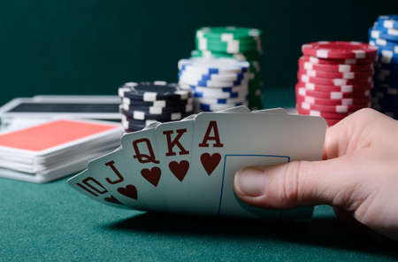 Casino chips and royal flush cards combination on the green table.の写真素材