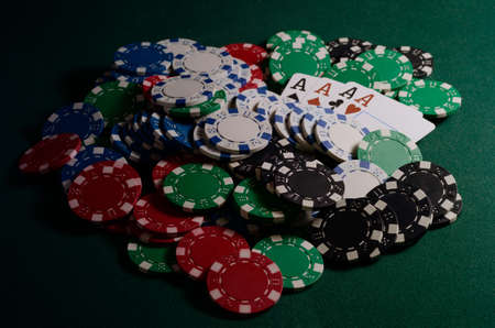 Stack of chips and four of kind poker combination on a green background. Poker game themeの写真素材