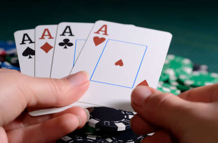 Casino chips and four of kind poker combination in a woman's hand.の写真素材