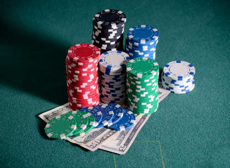 casino chips and dollar bills on the poker tableの写真素材