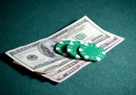 close-up casino chips and dollar bills on the poker tableの写真素材