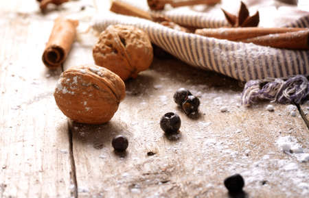 Christmas background with walnuts, cinnamon and anise on a rustic wooden table background.の写真素材