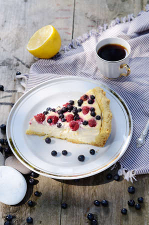 Sunny Photo with a morning breakfast in rustic style. Cheesecake raspberries and blueberries on wooden table.の写真素材