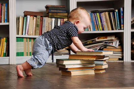 Eight months old todler baby playing with booksの写真素材