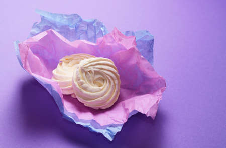 Food Photo of homemade zephyr, marshmallow wrapping paper. Healthy sweet dessert on a pink background.の写真素材