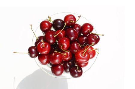 Fresh ripe red cherries berries in crystal vase on a white background top view picture