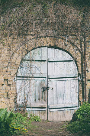 Old wooden doors. Entrance to abandoned brick building. Grunge backgroundの写真素材