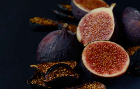 Close-up Picture of Fresh and dried Deep Blue Figs on a Dark Background. Tropical fruits on a tableの写真素材