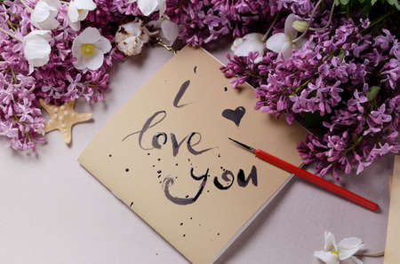 Romantic background with lilac flowers and notebook, sketchbook or diaryの写真素材