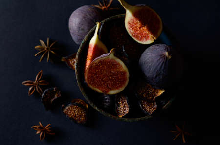 Close-up Picture of Fresh and dried Deep Blue Figs on a Dark Background. Tropical fruits on a tableの写真素材