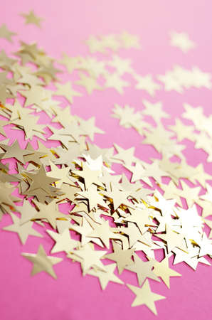 New Year background with sparkling decorative gold stars on a hipster pink backgroundの写真素材