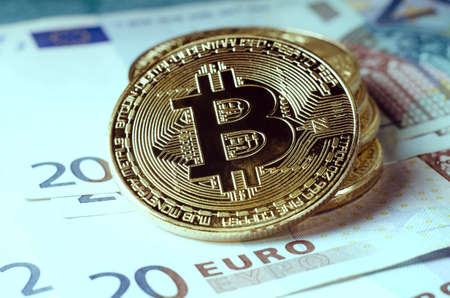 Physical Gold Bitcoin Coin against euro billsの写真素材