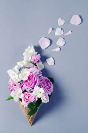 Fresh spring roses in waffle cone. Beautiful romantic background in flat lay style.の写真素材
